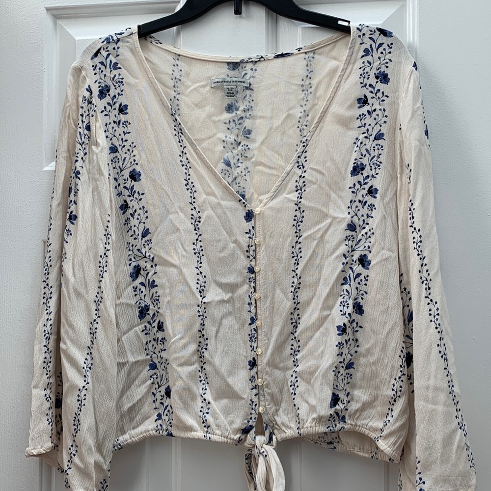 Cropped deep V ‘70s inspired boho top. Cream and blue floral